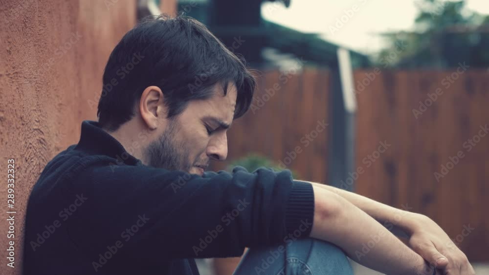 crying sad lonely young attractive man oudoor.pains of love, suffering