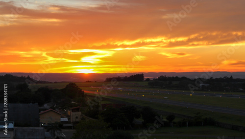 Sunrise over a calm regional airport runway photo