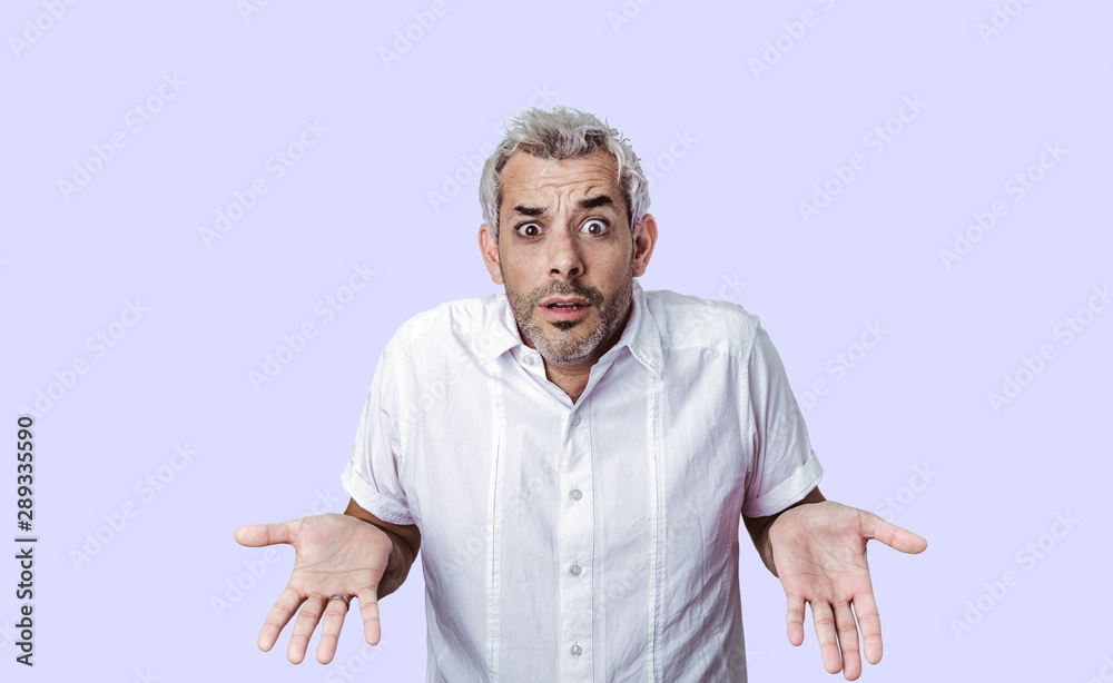 Human facial expressions concept.Indecisive dark skinned man spreads palms with confused expression, frowns face in uncertainty, has modern haircut, isolated over background. man faces trouble. Human facial expressions concept.Indecisive dark skinned man spreads palms with confused expression, frowns face in uncertainty, has modern haircut, isolated over background. man faces trouble.