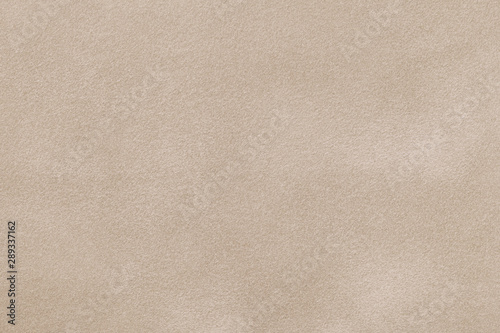 Light beige matte background of suede fabric, closeup.