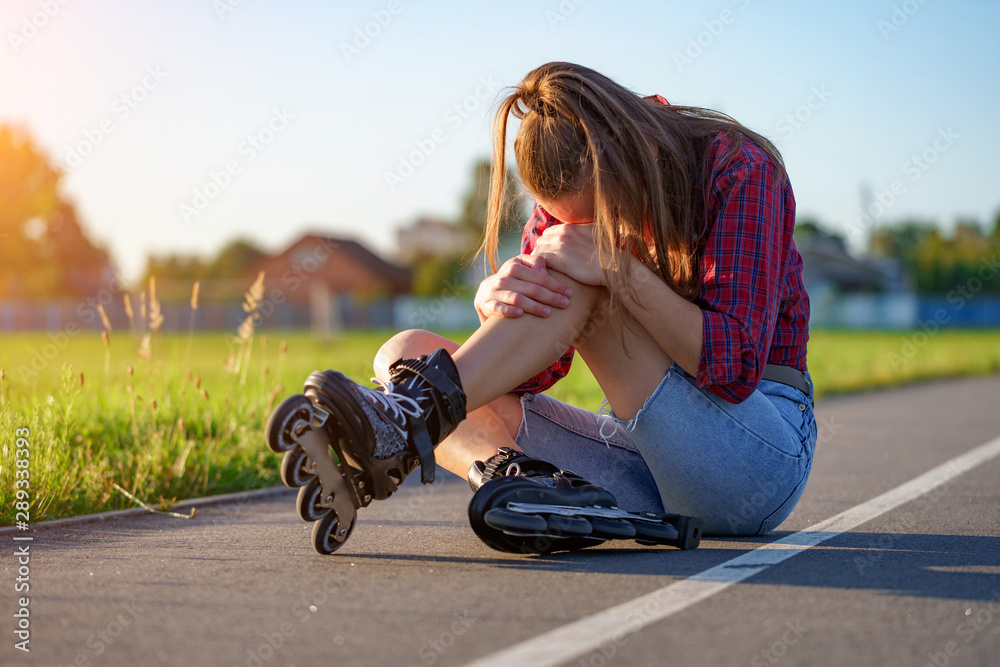 Woman injured knee while rollerblading. A teenager having a bruise ...