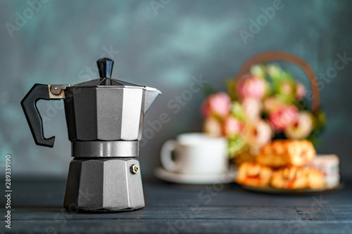 Fotografie Mocha coffee maker, flowers and sweets on dark background for coffee time