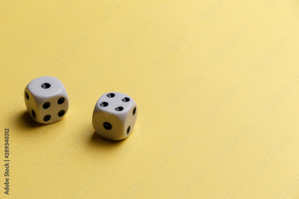 White gaming dice on yellow background. Top view. Flat lay. Copy space. Game of chance concept. Close-up. Pastel colors White gaming dice on yellow background. Top view. Flat lay. Copy space. Game of chance concept. Close-up. Pastel colors