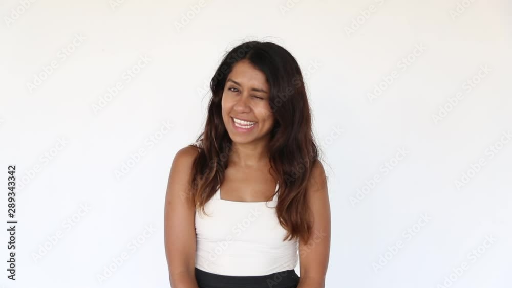 Pretty mexican young girl is blinking with one eye and pointing with fingers. Pretty mexican young girl is blinking with one eye and pointing with fingers.