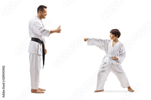 Karate instructor giving a thumb up to a boy exercising