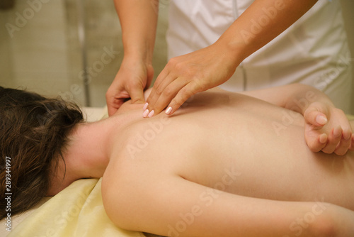 Closeup of masseur s hands doing weight loss massage on woman s back.