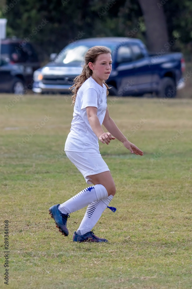 Young athletic teen girl playing in a soccer game Young athletic teen girl playing in a soccer game