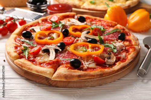 Delicious pizza and ingredients on white wooden background, close up