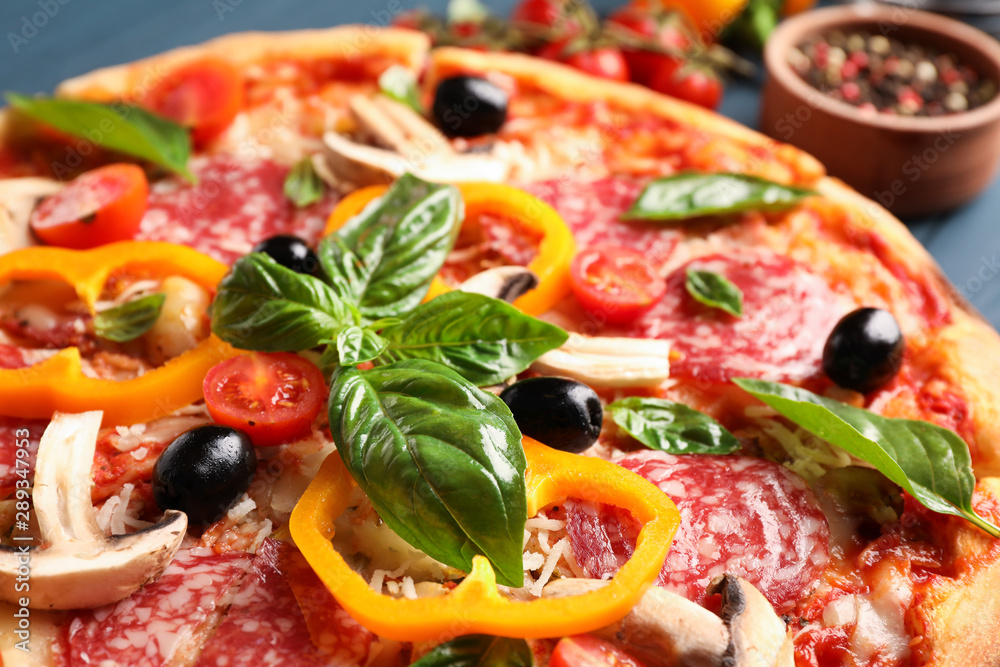Delicious pizza and ingredients on wooden background, close up Delicious pizza and ingredients on wooden background, close up