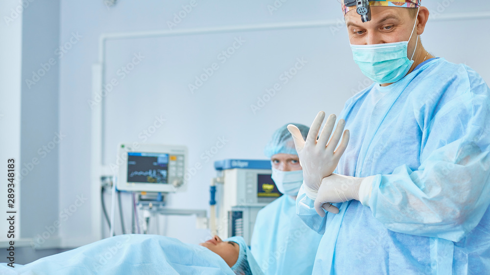 Several doctors surrounding patient on operation table during t Several doctors surrounding patient on operation table during t