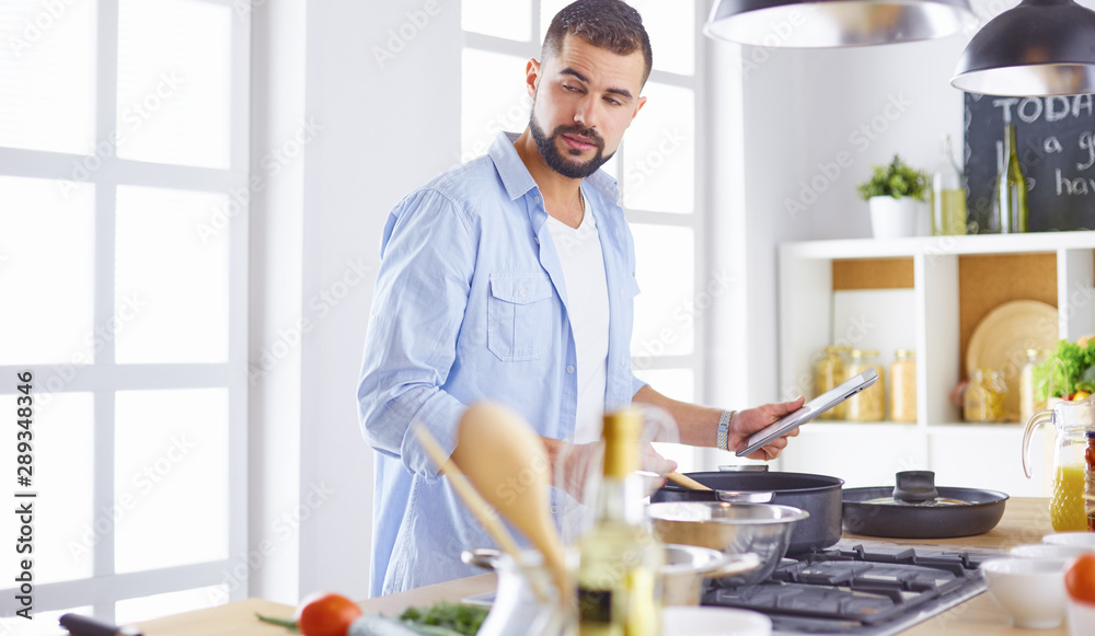 Smiling and confident chef standing in large kitchen Smiling and confident chef standing in large kitchen