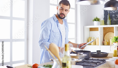 Smiling and confident chef standing in large kitchen