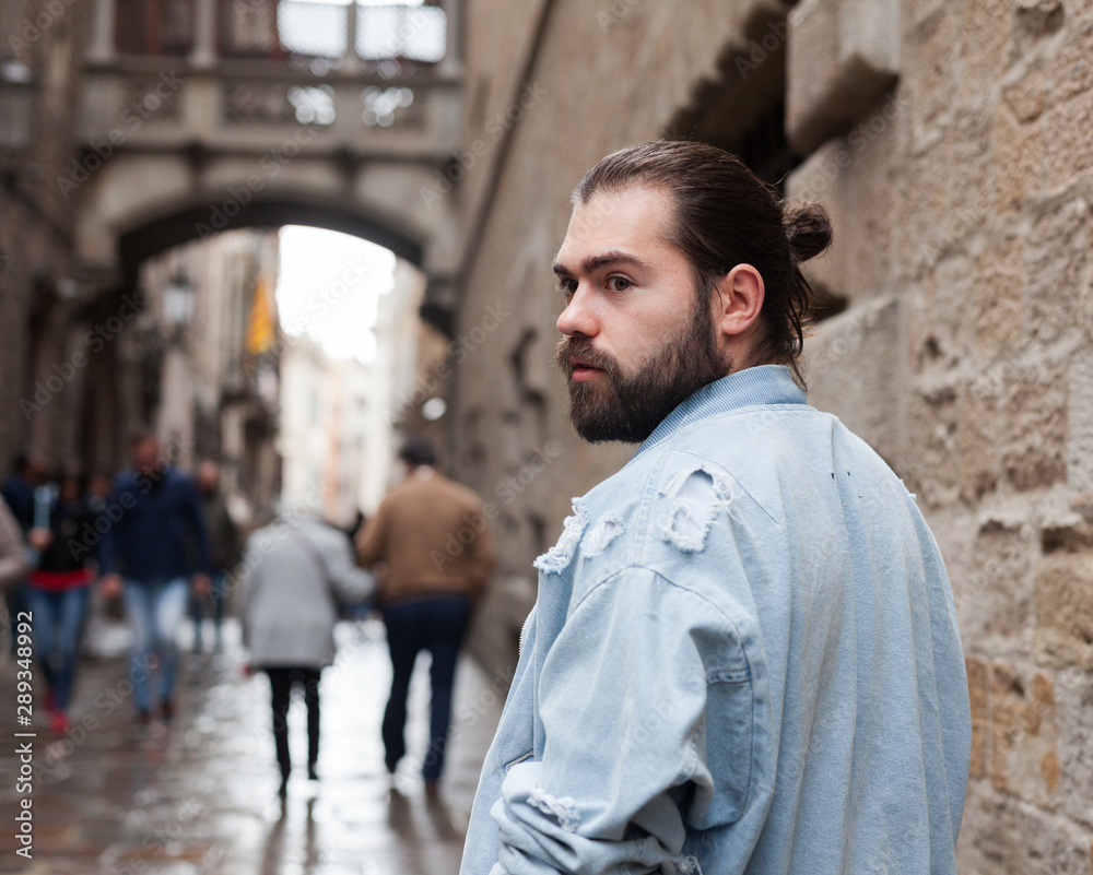 Fototapeta premium Handsome adult man with a beard in a jeans jacket