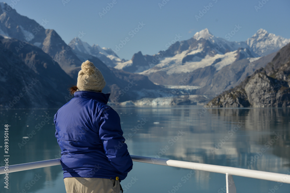 Woman looks out at the ocean and Glaciers in-front of her. Woman looks out at the ocean and Glaciers in-front of her.