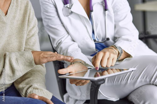 female doctor talking to a patient on a tablet