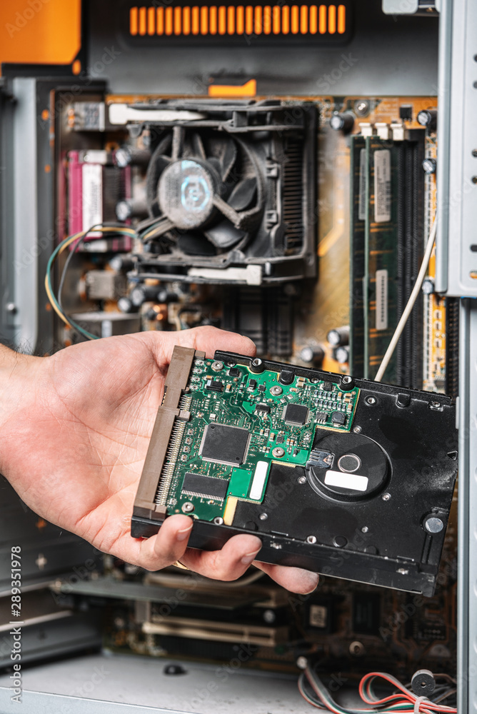 Closeup image of technician man hand changing the hard drive of pc computer . Maintenance and repair computer hardware service concept .