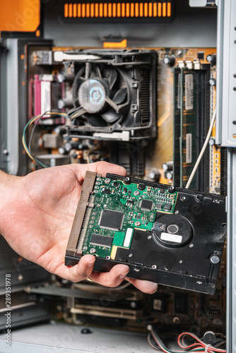 Closeup image of technician man hand changing the hard drive of pc computer . Maintenance and repair computer hardware service concept .