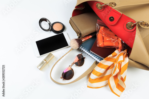 Fashion concept : Flat lay of brown leather woman bag open out with sunglasses and smartphone on white background. - Image