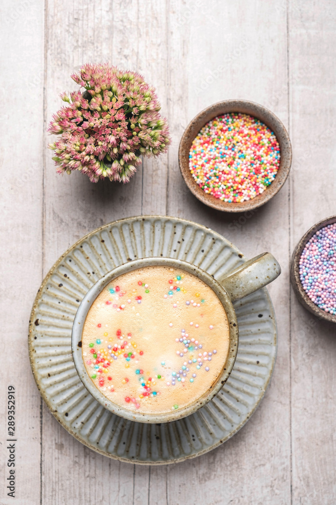Cappuccino coffee in a mug on a saucer..Flat lay composition of coffee, flowers and sweets, top view, copy space. Cappuccino coffee in a mug on a saucer..Flat lay composition of coffee, flowers and sweets, top view, copy space.