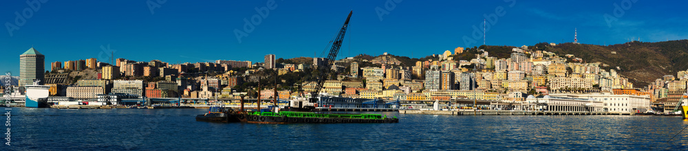 Old port of Genova city with cargo boats with crane at quay
