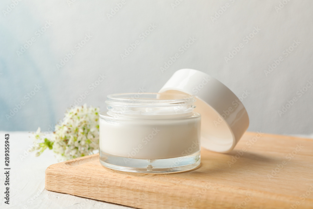 Jar with cream, allium flowers and board on white background, copy space Jar with cream, allium flowers and board on white background, copy space
