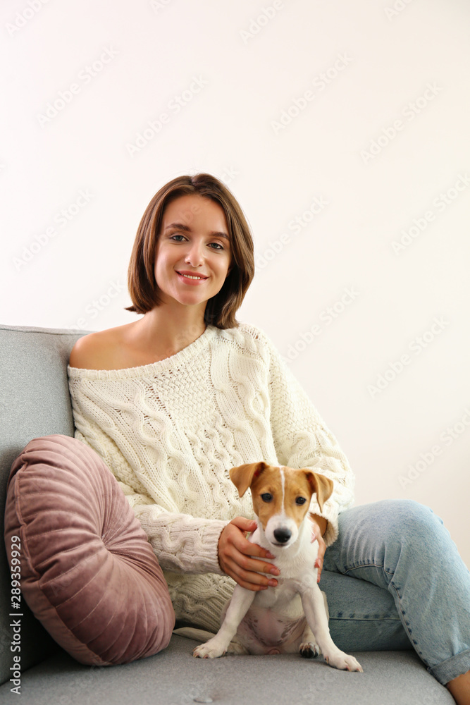Portrait of young beautiful hipster woman with her adorable four months old jack russell terrier puppy at home in living room full of natural sunlight. Lofty interior background, close up, copy space. Portrait of young beautiful hipster woman with her adorable four months old jack russell terrier puppy at home in living room full of natural sunlight. Lofty interior background, close up, copy space.