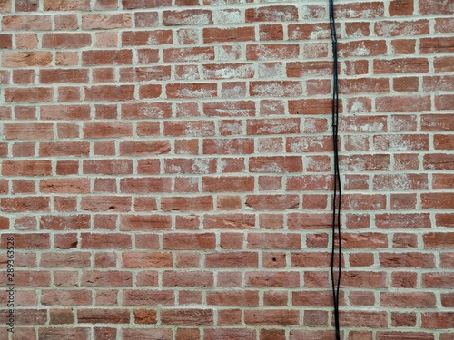 Brick wall with black cable, victorian, clay bricks