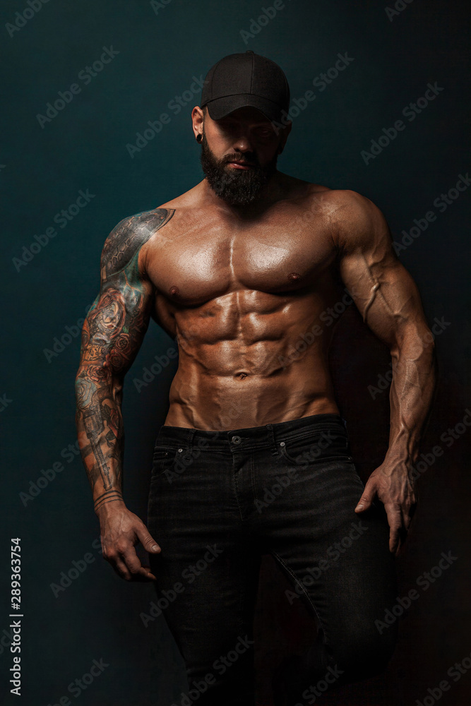 Strong and fit man bodybuilder bare-chested in black baseball cap. Sporty  muscular guy athlete. Sport and fitness concept. Men's fashion. Stock Photo  | Adobe Stock