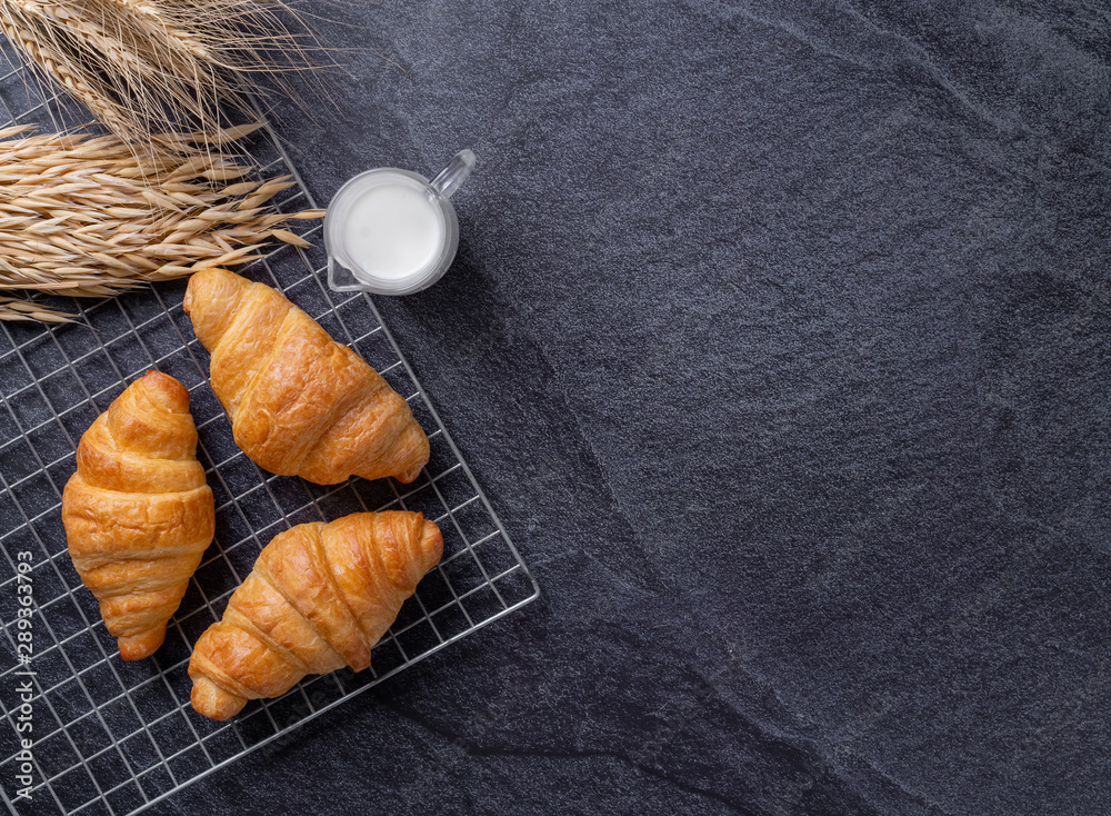 Fresh croissants on a black slate background. Top view Copy space