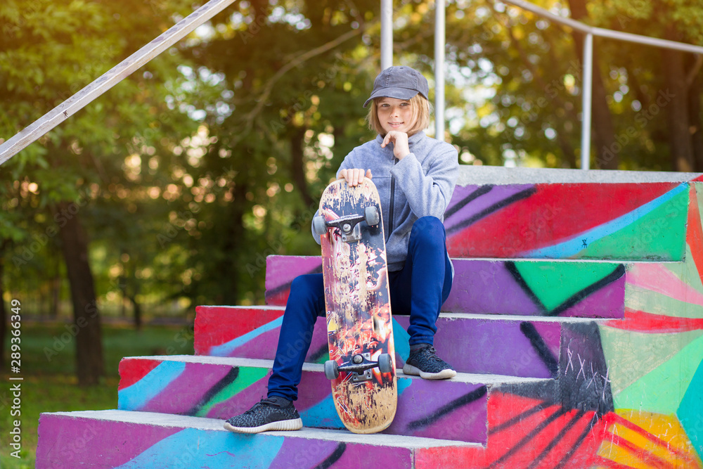 Fototapeta premium Young sporty girl riding on longboard in park.