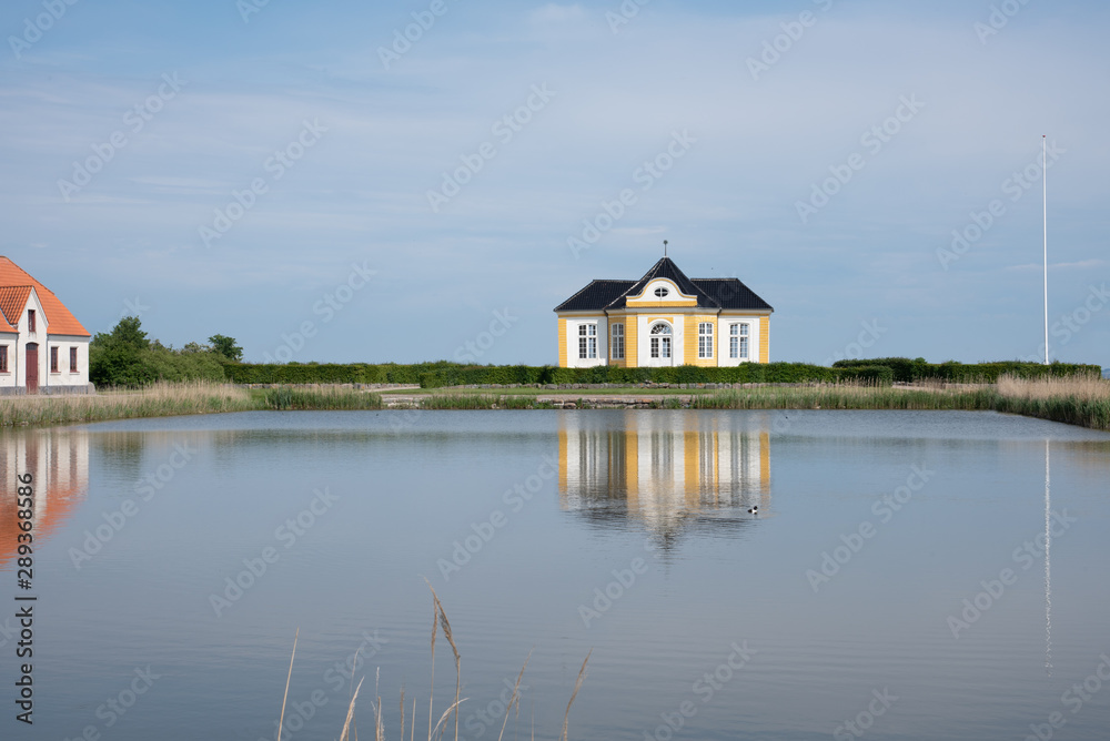 The yellow garden house at Taasinge Castle, reflecting in the moat The yellow garden house at Taasinge Castle, reflecting in the moat