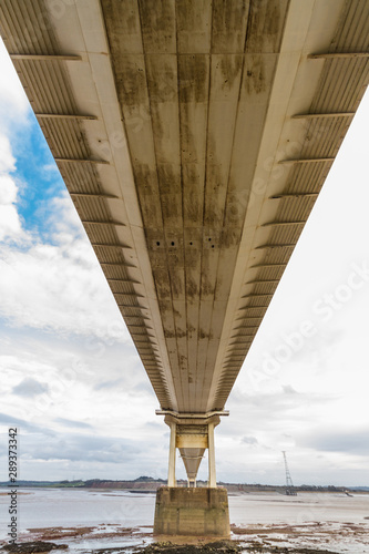 Underside of large road suspension bridge, portrait. photo