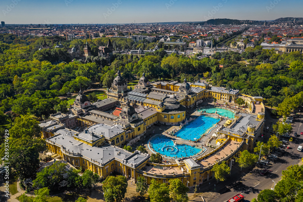 Fototapeta premium Budapest, Hungary - Aerial drone view of the famous Szechenyi Thermal Bath and Spa on a sunny summer day. Heroes' Square and Vajdahunyad Castle at background.