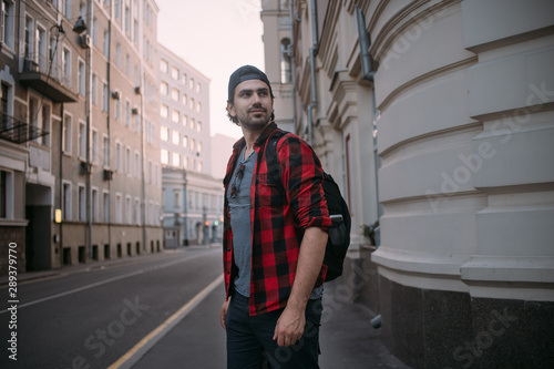 A man tourist walks through the streets with a backpack