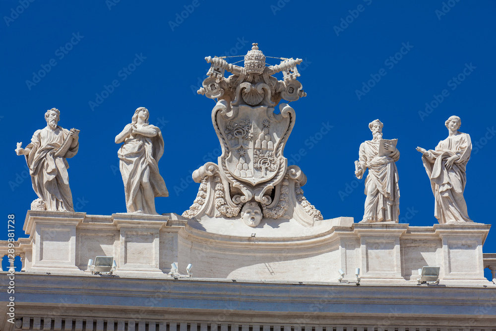 Obraz premium Detail of the Chigi coats of arms and the statues of saints that crown the colonnades of St. Peter Square built on 1667 on the Vatican City