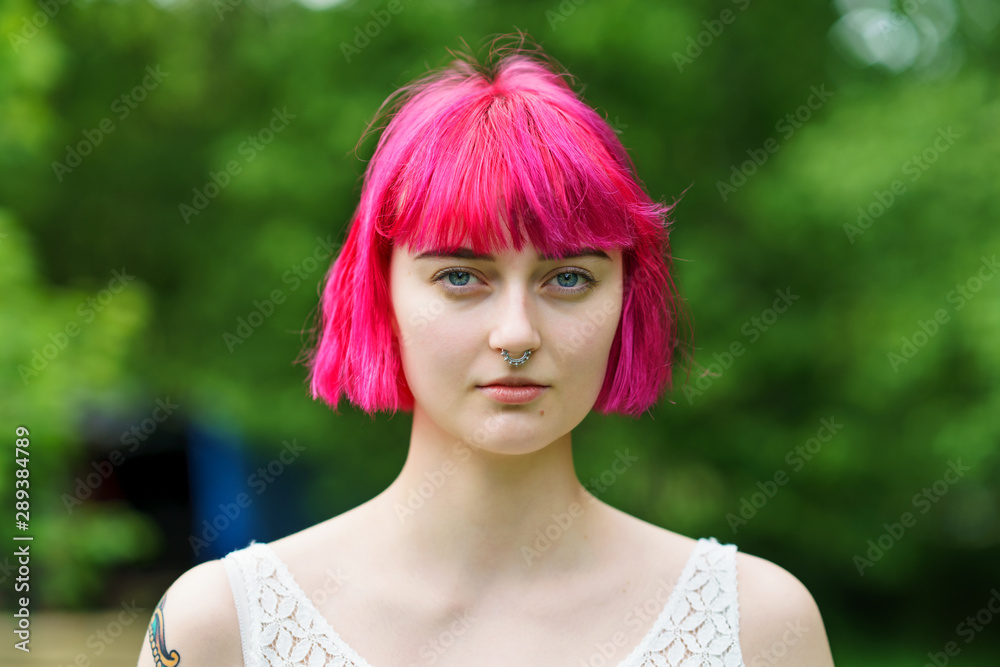 Pink Hair and Blue eyes beautiful young adult woman looking to camera 