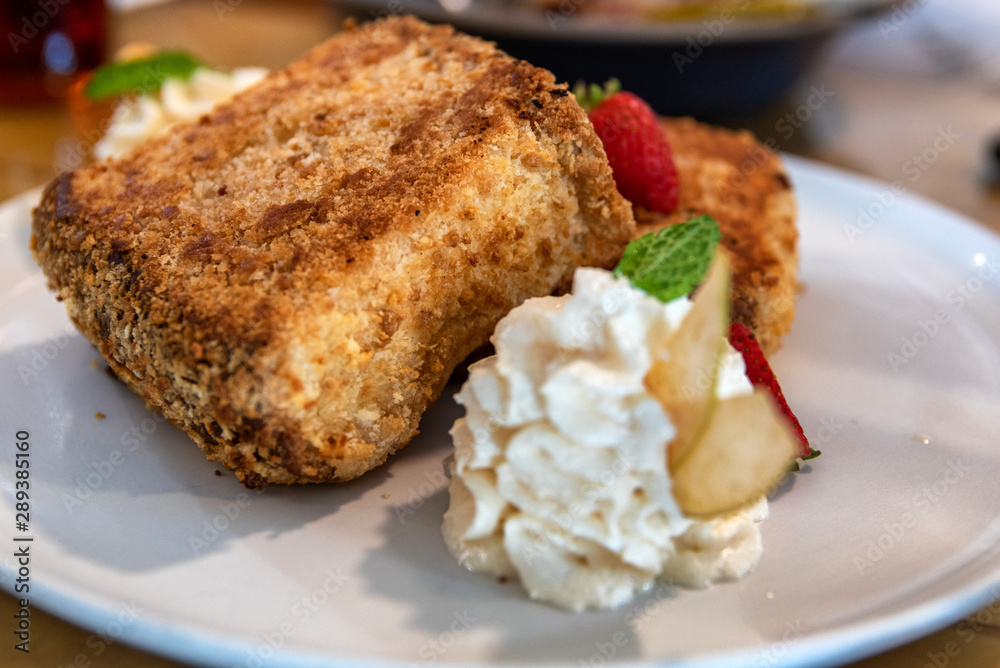 Plate of french toast served with sliced fruits and creme fraiche Plate of french toast served with sliced fruits and creme fraiche