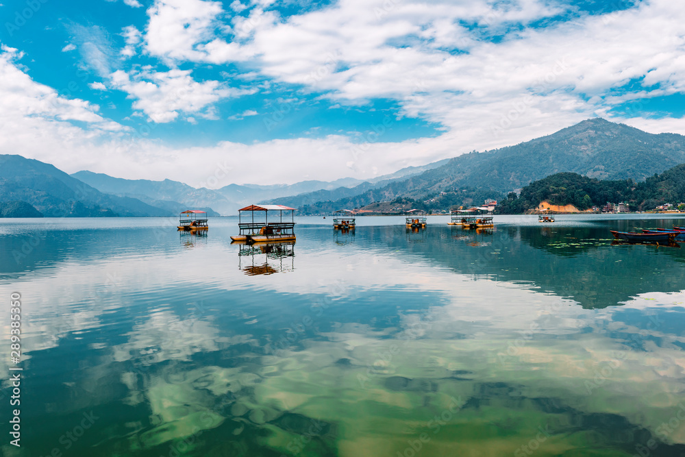Naklejka premium Colourful wooden tourist boats in Pokhara lake in Nepal.
