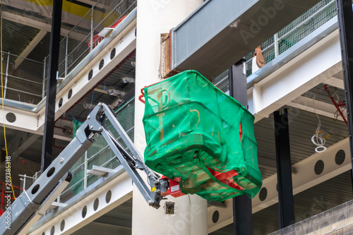 Lifting boom or basket lift platform on construction site. Industrial machine, work on height equipment concept. photo