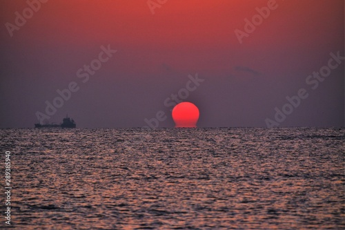a sunrise at the seashore in blue-red hues