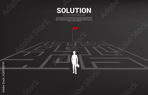 Silhouette of businessman enter to maze to red flag. business concept for finding solution and reach goal