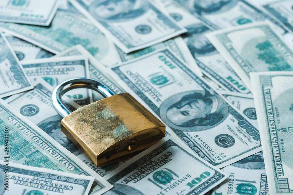 selective focus of metallic padlock on dollar banknotes selective focus of metallic padlock on dollar banknotes
