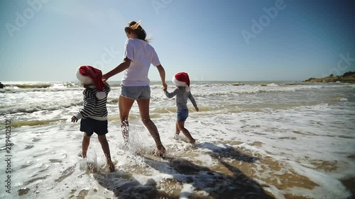 Happy family in Santa hat  having fun on summer vacation on Christmas and New year on tropical beach. Holiday Travel and adventure concept