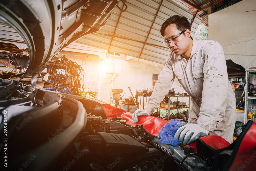 mechanic in uniform is working in auto service. Car repair and maintenance. mechanic working in garage. Repair service concept.