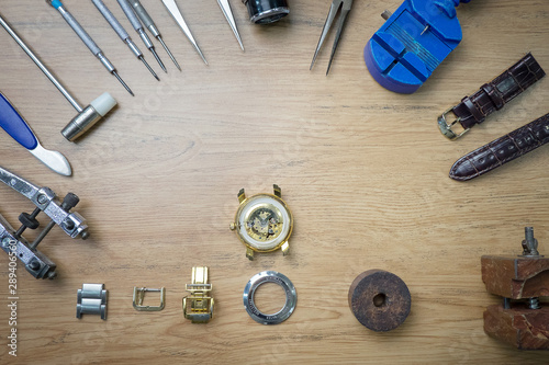 Watchmaker hands close mechanism repair With tools placed on the table