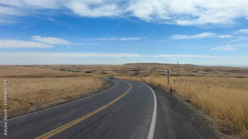 Truck towing a fishing boat on the highway and driving away from the camera in the Scablands in Eastern Washington State Truck towing a fishing boat on the highway and driving away from the camera in the Scablands in Eastern Washington State