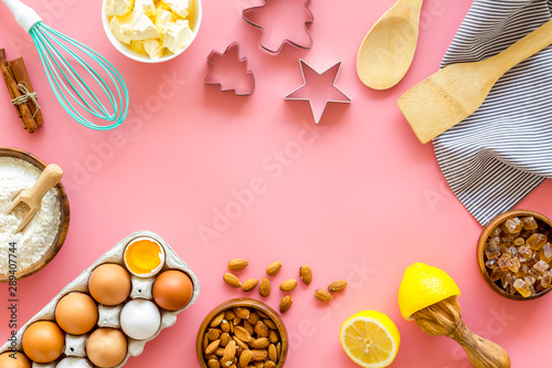 Cooking for Christmas or New Year dinner. Ingredients and utensil on pink background top view space for text