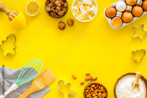 Cooking for Christmas or New Year dinner. Ingredients and utensil on yellow background top view copy space