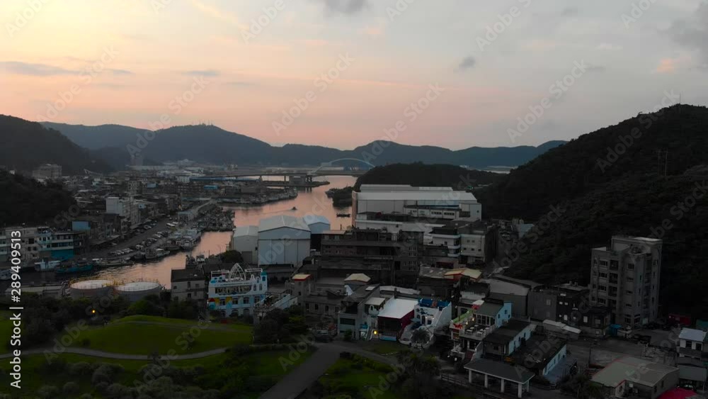AERIAL: Rise Up Over Fishing Harbor In Sunset With City View And Mountains On Horizon - Taiwan AERIAL: Rise Up Over Fishing Harbor In Sunset With City View And Mountains On Horizon - Taiwan