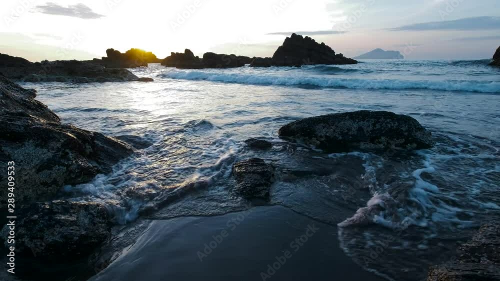 Early Morning Sun Over Ocean with Rocks and Gentle Waves - Blue and Yellow Colors - Yilan, Taiwan